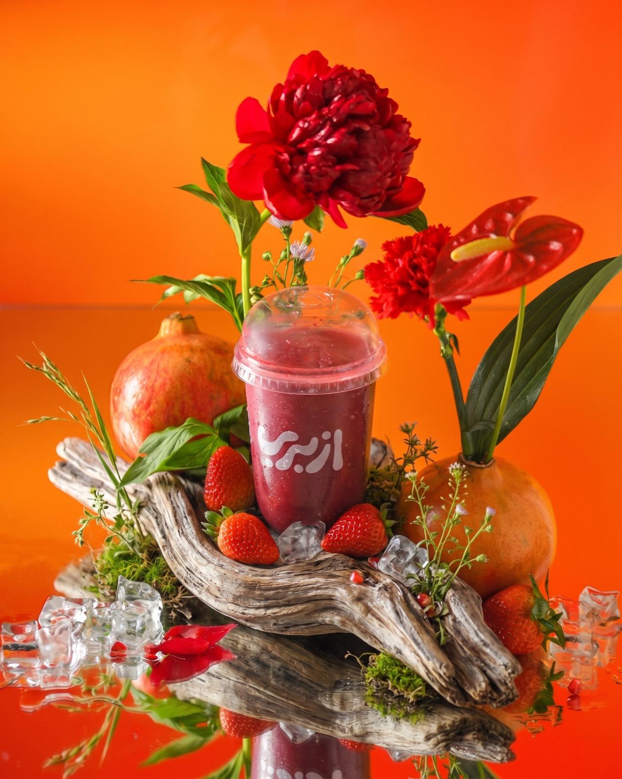 AzBerry berry cup styled with pomegranate, strawberries and flowers